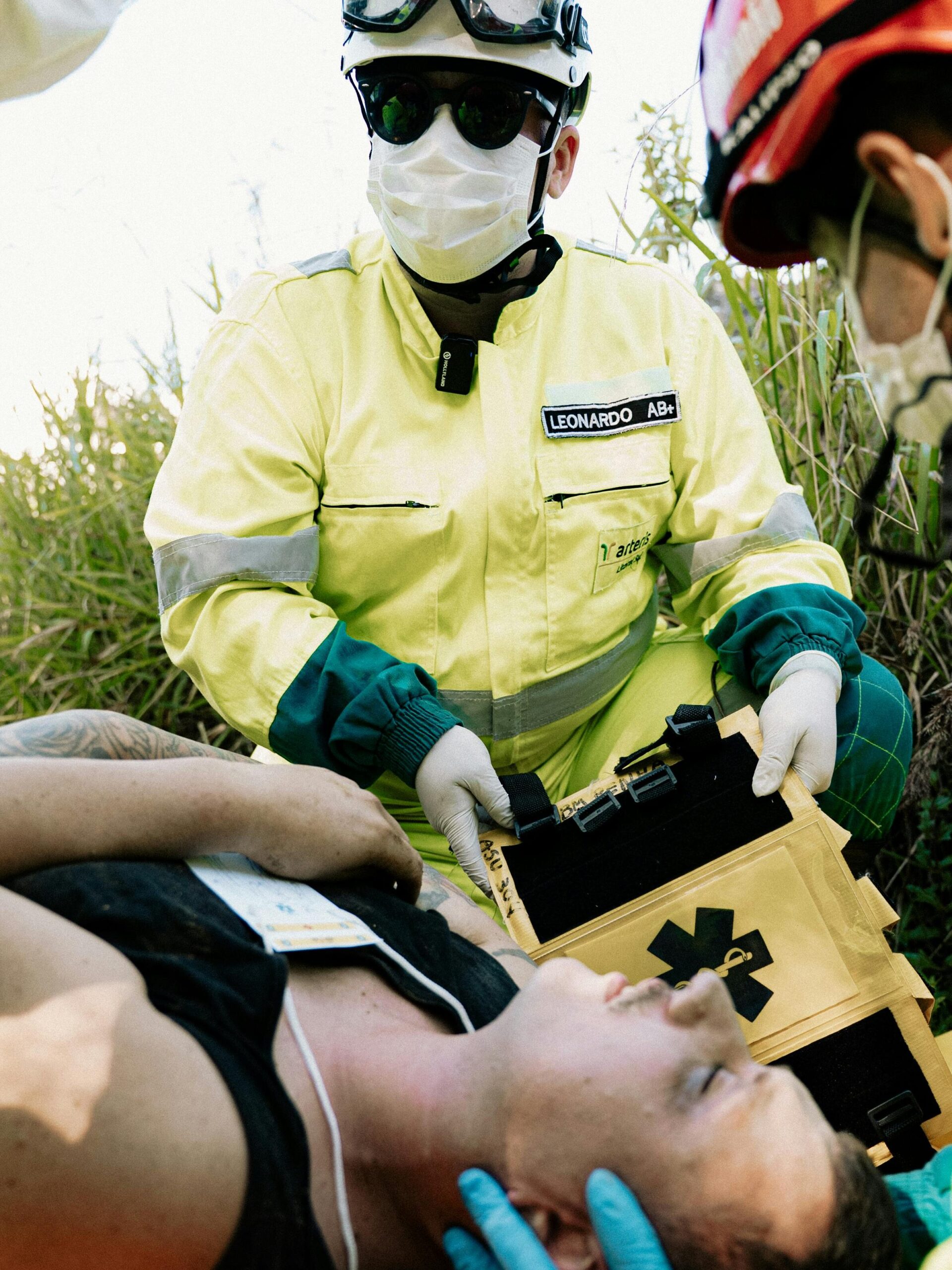 Emergency responders in action assisting a patient outdoors during a medical simulation.